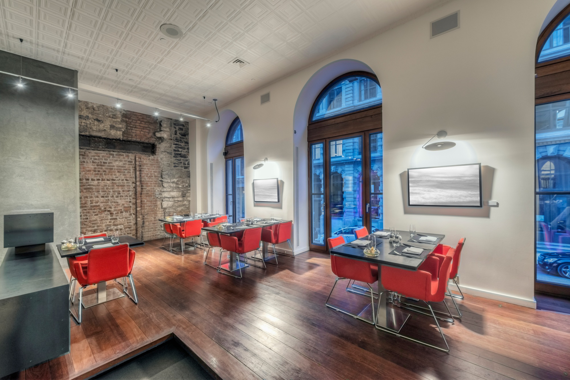 Modern restaurant interior with red chairs.