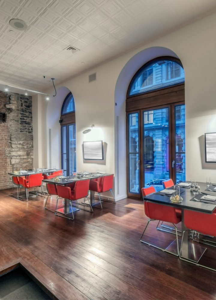 Modern restaurant interior with red chairs.